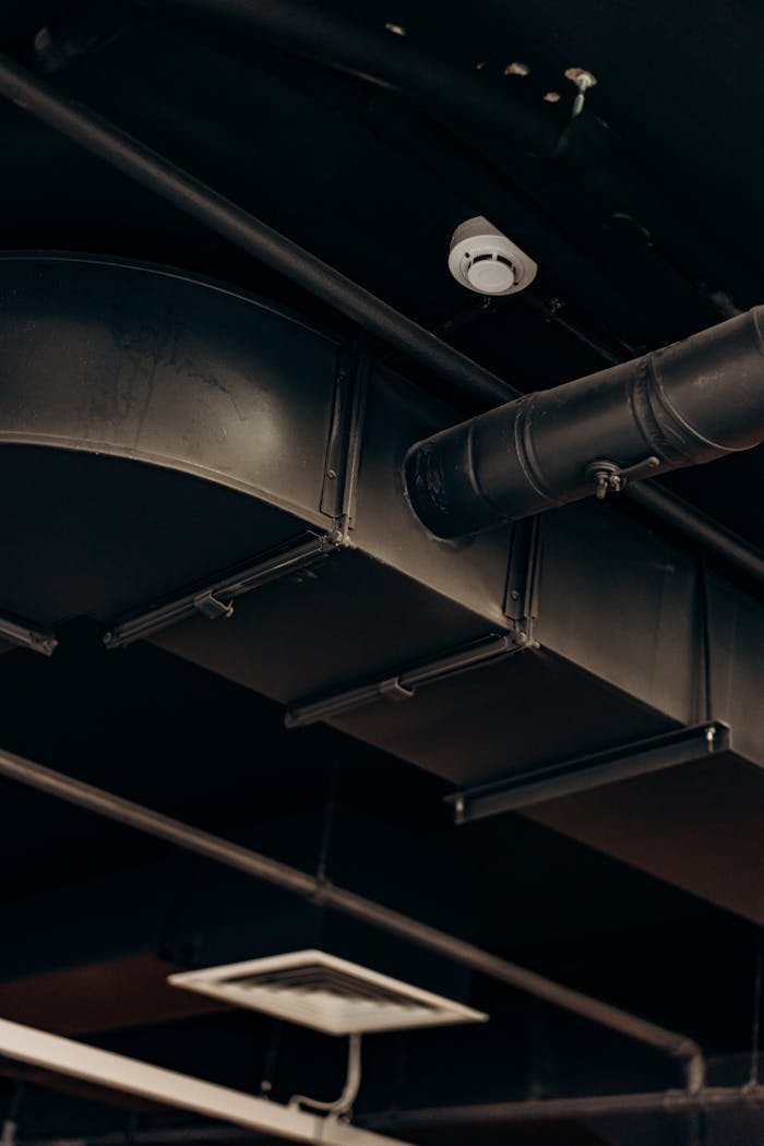 Detailed view of industrial air ducts on a ceiling, showcasing modern urban design.
